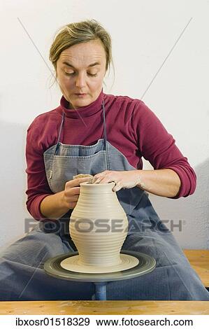 "Ceramic artist working in her workshop with a potter's wheel, turning a vase, Geisenhausen, Bavaria, Germany, Europe" View Large Photo Image Stock Photo - "Ceramic artist working in her workshop with a potter's wheel, turning a vase, Geisenhausen, Bavaria, Germany, Europe". Fotosearch