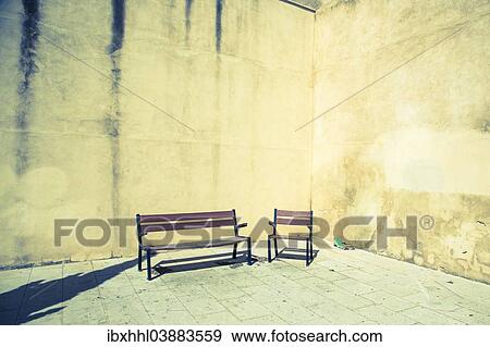 Chair and bench in front of house wall View Large Photo Image Stock Photo - Chair and bench in front of house wall. Fotosearch