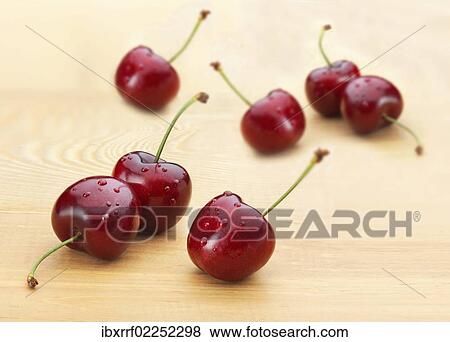 "Cherries (Prunus avium), dew drops, on a wooden board" View Large Photo Image Stock Photo - "Cherries (Prunus avium), dew drops, on a wooden board". Fotosearch