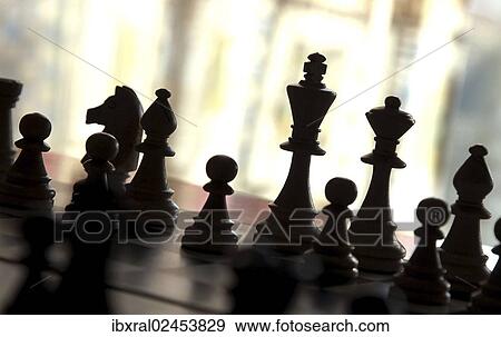 "Chess pieces on a chessboard, backlit" View Large Photo Image Stock Photo - "Chess pieces on a chessboard, backlit". Fotosearch