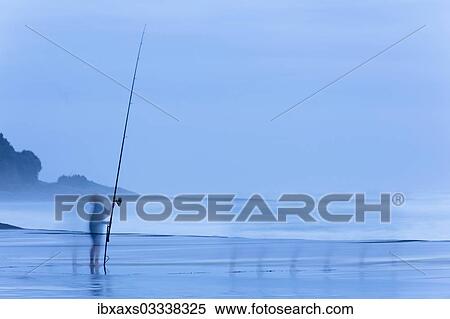 Stock Photography - "Child on beach with a fishing rod at dusk, Oakura, Taranaki Region, New Zealand, Oceania". Fotosearch