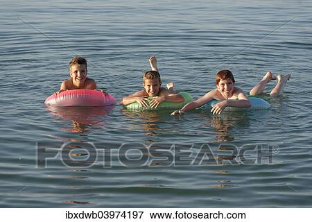 Stock Photo - "Children on floating tyres in the sea, Mediterranean near Fano, Marche, Adriatic, Italy, Europe". Fotosearch