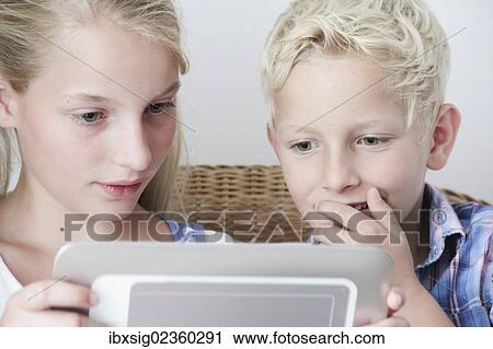 Stock Image - Children playing with a digital tablet. Fotosearch