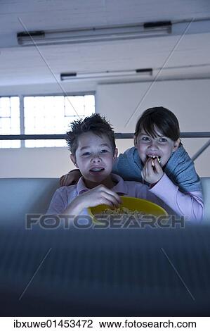 Stock Image - Children with popcorn watching television. Fotosearch