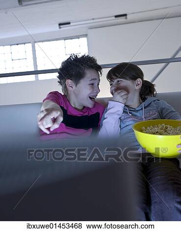 Children with popcorn watching television View Large Photo Image Stock Photo - Children with popcorn watching television. Fotosearch