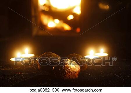 Stock Image - Chocolate muffins and tea light candles. Fotosearch