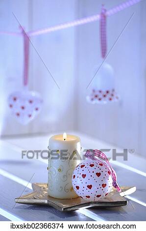 Picture - Christmas ambience with Christmas tree ornaments made of glass and a candle. Fotosearch