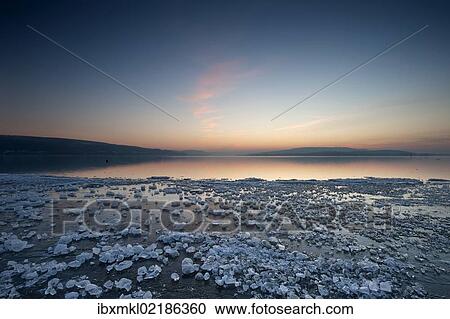 "Chunks of ice lying on icy surface on the shore of Reichenau Island after sunset, Baden-Wuerttemberg, Germany, Europe" View Large Photo Image Stock Image - "Chunks of ice lying on icy surface on the shore of Reichenau Island after sunset, Baden-Wuerttemberg, Germany, Europe". Fotosearch