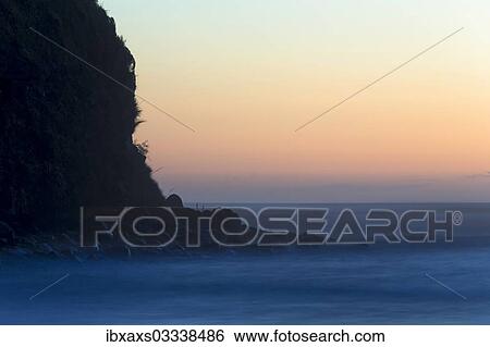 Stock Photograph - "Cliffs and surf after sunset, Opunake, Taranaki Region, New Zealand, Oceania". Fotosearch