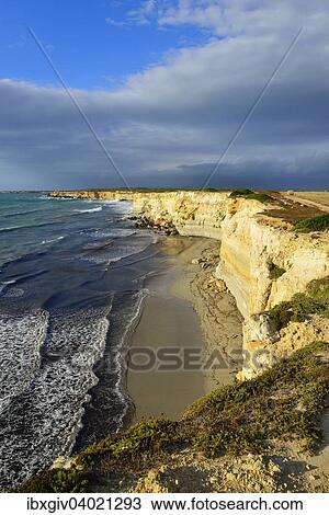 Stock Image - "Cliffs in the evening light with rain clouds, Mari Ermi, Sinis Peninsula, Province of Oristano, Sardinia, Italy, Europe". Fotosearch