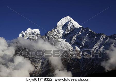 Stock Image - "Clouds in front of Mt. Kangtega and Mt. Thamserku, Khumbu, Sagarmatha National Park, Nepal, Asia". Fotosearch