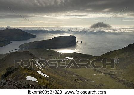 "Coastal landscape with Kollur Mountain and the sea stacks of Risin and Kellingin in the evening light, Eioi, Eysturoy, Faroe Islands, Denmark, Europe" View Large Photo Image Stock Image - "Coastal landscape with Kollur Mountain and the sea stacks of Risin and Kellingin in the evening light, Eioi, Eysturoy, Faroe Islands, Denmark, Europe". Fotosearch