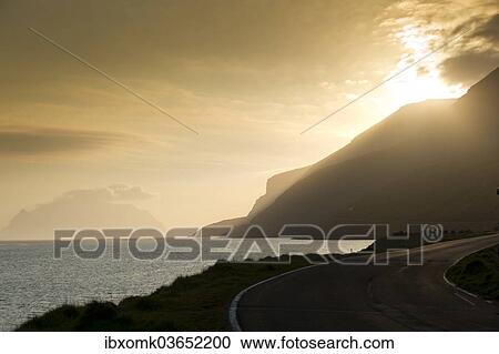 "Coastal road, sea and clouds, evening mood, backlighting, Mykines Island at the rear, Mykines, Faroe Islands, Denmark, Europe" View Large Photo Image Stock Image - "Coastal road, sea and clouds, evening mood, backlighting, Mykines Island at the rear, Mykines, Faroe Islands, Denmark, Europe". Fotosearch