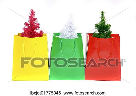 Stock Photograph - "Colorful gift bags with small plastic Christmas trees, Christmas shopping". Fotosearch