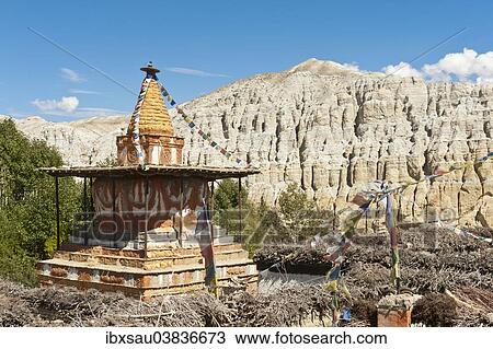 Stock Image - "Colorful ornate Buddhist stupa, eroded landscape at the back, Charang, Mustang District, Nepal, Asia". Fotosearch
