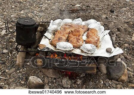 "Cooking on a camp fire, BBQ, steaks and baked potatoes, tea cattle, upper Liard River, Yukon Territory, Canada, North America" View Large Photo Image Stock Photograph - "Cooking on a camp fire, BBQ, steaks and baked potatoes, tea cattle, upper Liard River, Yukon Territory, Canada, North America". Fotosearch