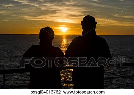 "Couple at the railing of a ship watching the sunset on the North Atlantic coast of Thurso, Scotland, United Kingdom, Europe" View Large Photo Image Stock Image - "Couple at the railing of a ship watching the sunset on the North Atlantic coast of Thurso, Scotland, United Kingdom, Europe". Fotosearch