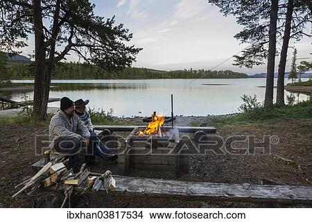 "Couple sitting at a campfire, campsite on Arrenjarka island, Kvikkjokk, Norrbotten County, Sweden, Europe" View Large Photo Image Picture - "Couple sitting at a campfire, campsite on Arrenjarka island, Kvikkjokk, Norrbotten County, Sweden, Europe". Fotosearch