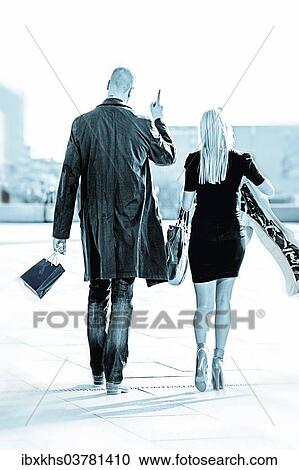 Stock Image - "Couple, walking and talking, rear view". Fotosearch