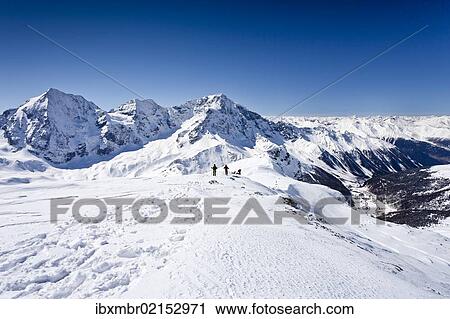 Stock Image - "Cross-country skiers descending Hintere Schoentaufspitze Mountain, Solda, looking towards Koenigsspitze Mountain, Zebru Mountain Ortler Mountain and the Suldental Valley, Alto Adige, Italy, Europe". Fotosearch