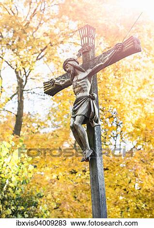 Stock Image - "Crucifix with fall trees, cemetery in Stockholm, Sweden, Europe". Fotosearch