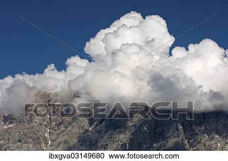 "Cumulus clouds looming over a mountain ridge, Ehrwald, Tyrol, Austria, Europe" View Large Photo Image Stock Image - "Cumulus clouds looming over a mountain ridge, Ehrwald, Tyrol, Austria, Europe". Fotosearch