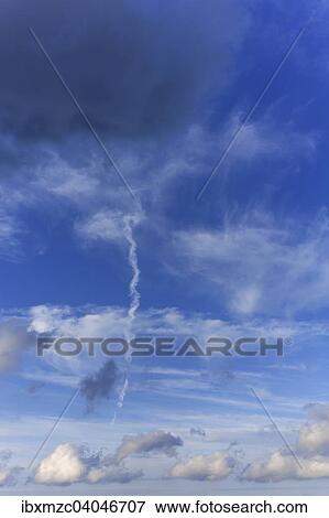 Stock Photo - "Cumulus, stratocumulus cumulogenitus, above rain clouds, nimbostratus, in the middle a disintegrating contrails". Fotosearch