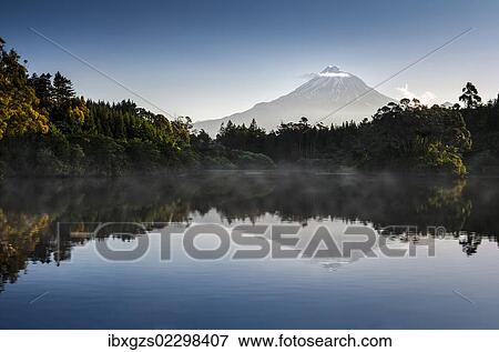 Stock Photo - "Currently inactive volcano, Mt Egmont, Mt Taranaki, reflections in Lake Mangamahoe reservoir, dam, North Island, New Zealand, Oceania". Fotosearch