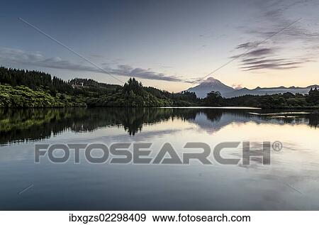 Stock Photo - "Currently inactive volcano, Mt Egmont, Mt Taranaki, reflections in Lake Mangamahoe reservoir, dam, North Island, New Zealand, Oceania". Fotosearch