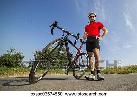 Stock Image - "Cyclist, 44 years, standing next to a racing cycle, Winterbach, Baden-Wurttemberg, Germany, Europe". Fotosearch