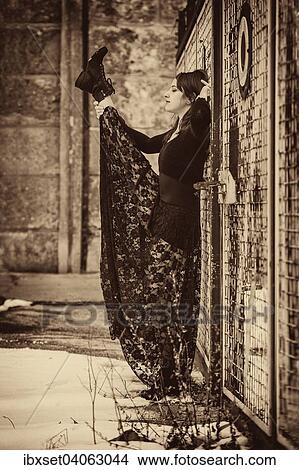 Dancer in a black dress performing in front of an old fence in winter View Large Photo Image Picture - Dancer in a black dress performing in front of an old fence in winter. Fotosearch