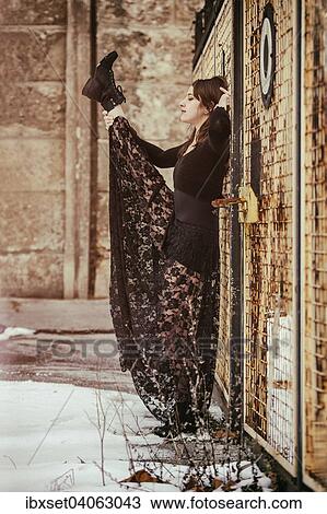 Dancer in a black dress performing in front of an old fence in winter View Large Photo Image Stock Image - Dancer in a black dress performing in front of an old fence in winter. Fotosearch
