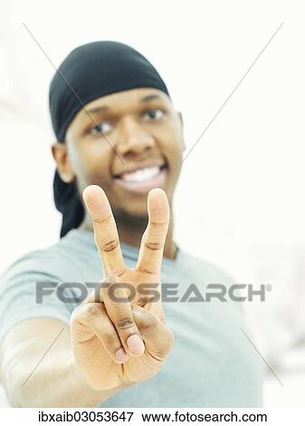 Dark-skinned man wearing a bandana and making a victory sign View Large Photo Image Stock Photo - Dark-skinned man wearing a bandana and making a victory sign. Fotosearch