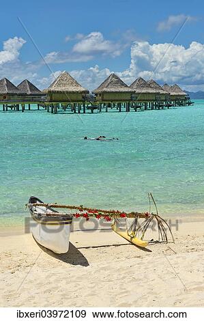 Stock Photo - "Decorated outrigger boat in front of overwater bungalows, Bora Bora, French Polynesia, Oceania". Fotosearch