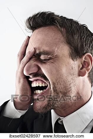 "Desperate young man wearing a suit covering his face with his hand, screaming" View Large Photo Image Stock Photo - "Desperate young man wearing a suit covering his face with his hand, screaming". Fotosearch