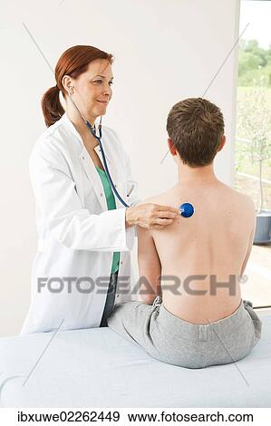 Doctor examining a teenage boy with a stethoscope View Large Photo Image Stock Photo - Doctor examining a teenage boy with a stethoscope. Fotosearch