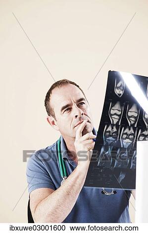 Stock Image - "Doctor looking at an X-ray, Mannheim, Baden-Wurttemberg, Germany, Europe". Fotosearch