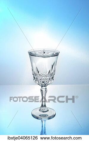 Drop falling into a glass filled with water View Large Photo Image Stock Photograph - Drop falling into a glass filled with water. Fotosearch