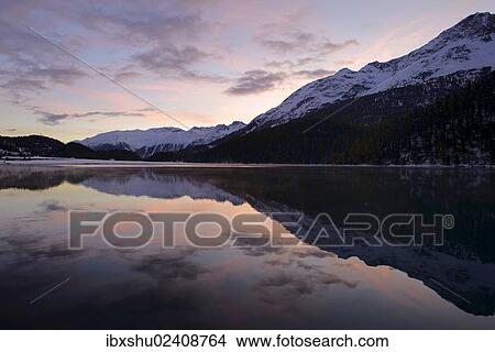 "Early morning mood at Lake Champfer with a reflection of snow-covered mountains, St. Moritz, Engadine, Grisons, Switzerland, Europe" View Large Photo Image Picture - "Early morning mood at Lake Champfer with a reflection of snow-covered mountains, St. Moritz, Engadine, Grisons, Switzerland, Europe". Fotosearch