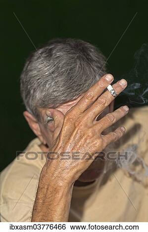 Elderly man smoking a cigarette View Large Photo Image Stock Photograph - Elderly man smoking a cigarette. Fotosearch