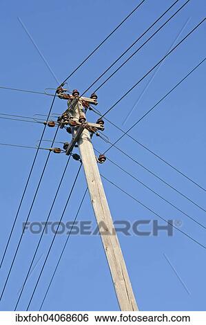 Electricity pylon with power lines and isolators against blue sky View Large Photo Image Stock Photograph - Electricity pylon with power lines and isolators against blue sky. Fotosearch
