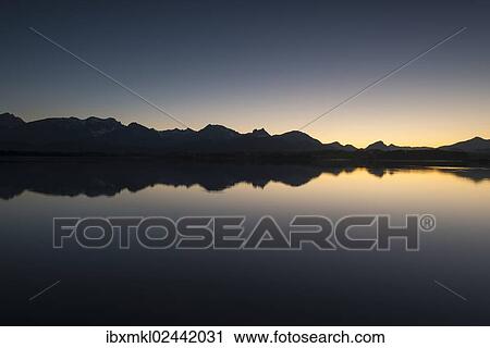 "Evening light on the shore of Hopfensee Lake, Allgaeu Alps at back, Fuessen, Ostallgaeu region, Allgaeu, Bavaria, Germany, Europe" View Large Photo Image Stock Image - "Evening light on the shore of Hopfensee Lake, Allgaeu Alps at back, Fuessen, Ostallgaeu region, Allgaeu, Bavaria, Germany, Europe". Fotosearch