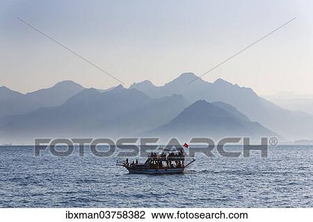 Stock Image - "Excursion boat on the sea, in front of the Taurus Mountains, Lycian Taurus, Antalya, Turkish Riviera, Province of Antalya, Mediterranean Region, Turkey, Asia". Fotosearch