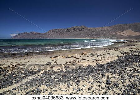 Stock Image - "Famara beach, Playa de Famara, in the back Risco de Famara, Lanzarote, Canary Islands, Spain, Europe". Fotosearch