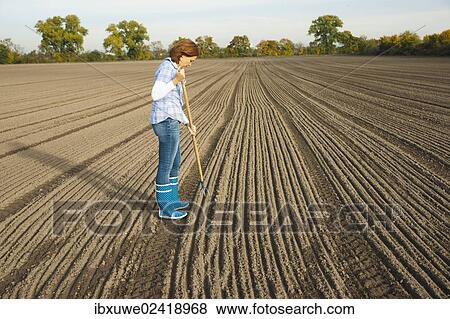 Farmer working in her field View Large Photo Image Stock Photo - Farmer working in her field. Fotosearch
