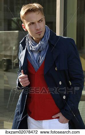 Stock Image - "Fashion image, young man wearing a blue coat and a red sweater". Fotosearch