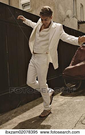 Fashion photo of a young man wearing a white suit standing in front of a wooden fence View Large Photo Image Stock Photography - Fashion photo of a young man wearing a white suit standing in front of a wooden fence. Fotosearch