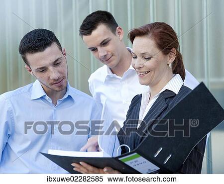 Female boss showing her employees something in a folder View Large Photo Image Stock Photography - Female boss showing her employees something in a folder. Fotosearch