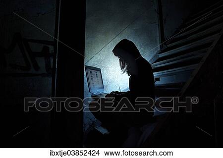 "Female computer hacker sitting with a laptop in the dark, in an old building" View Large Photo Image Picture - "Female computer hacker sitting with a laptop in the dark, in an old building". Fotosearch
