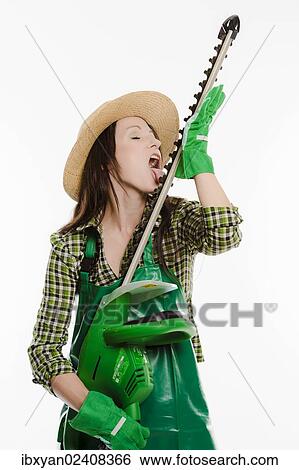 Female gardener holding a hedge trimmer View Large Photo Image Stock Photograph - Female gardener holding a hedge trimmer. Fotosearch